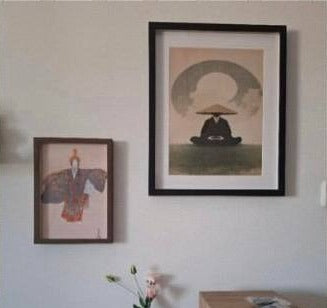 Dva japanska postera iznad stola, u braon i crnom ramu