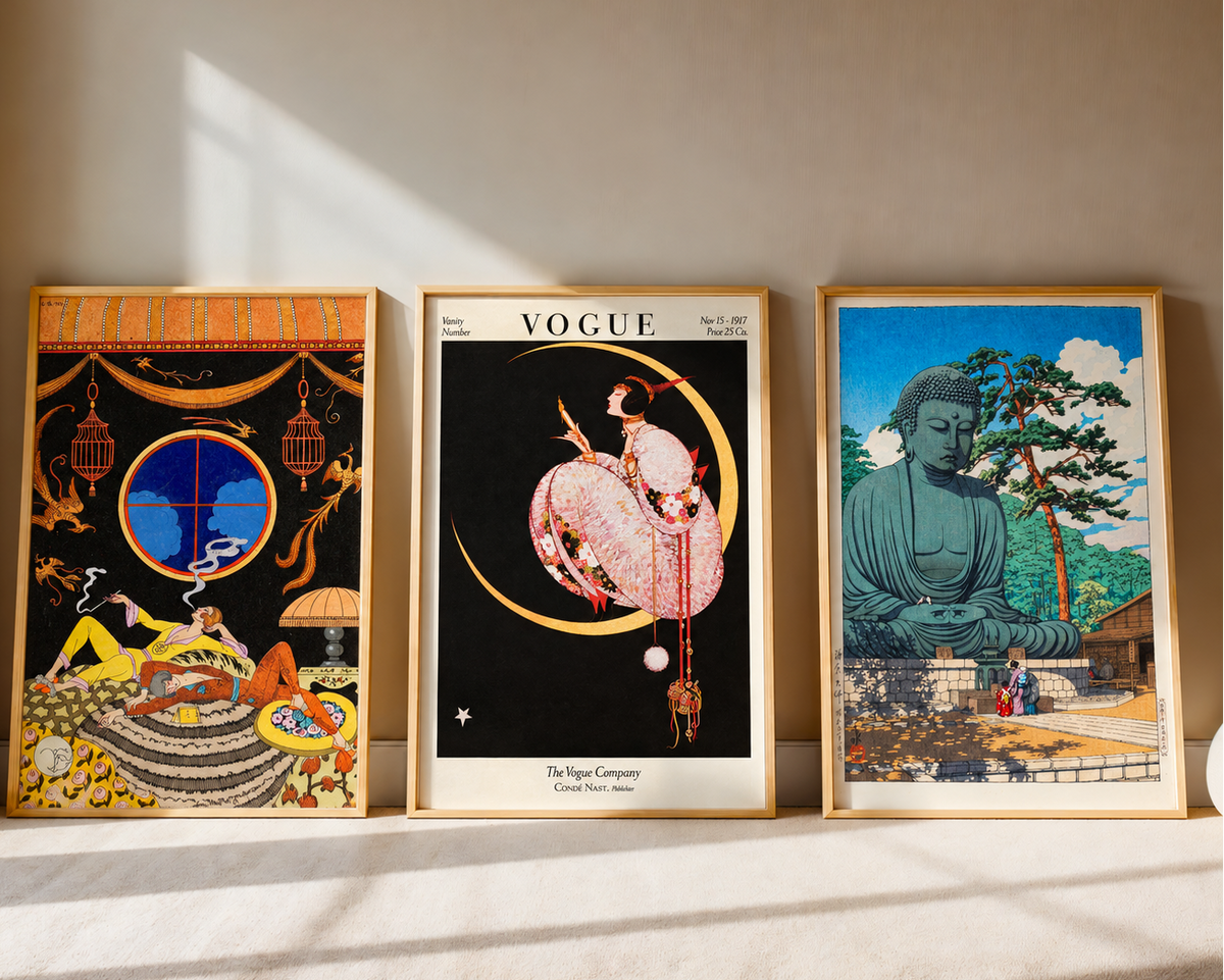 Tri uramljena postera naslonjena na zid: art deco ilustracija, Vogue naslovnica i japanski drvorez